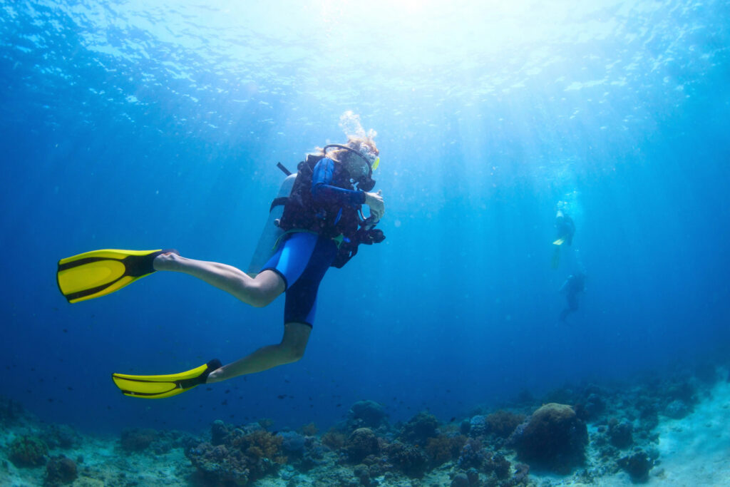 Scuba diver exploring a coral reef in clear blue water