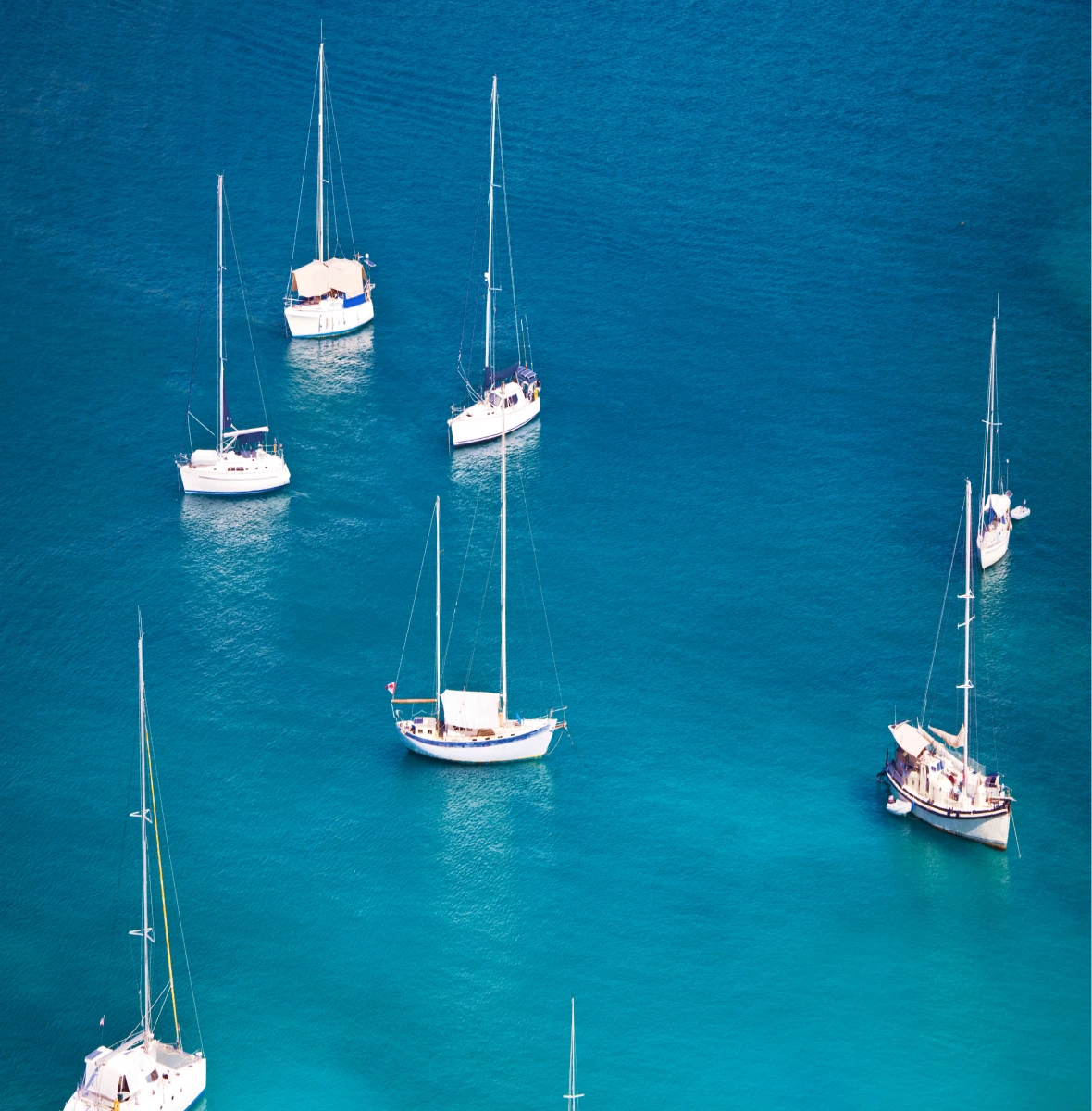 Sailboats anchored in clear blue Caribbean water