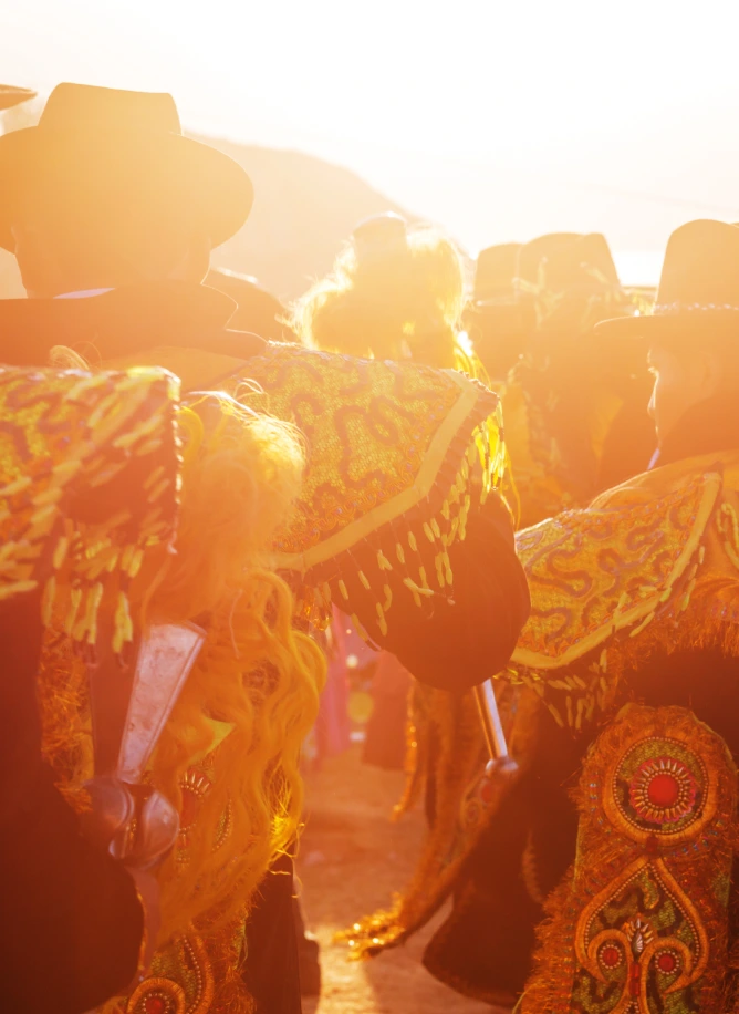 Costumed dancers at a festival at sunset