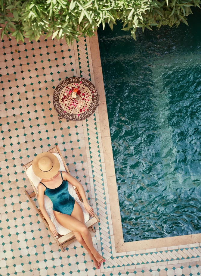 Woman sunbathing beside a tiled pool
