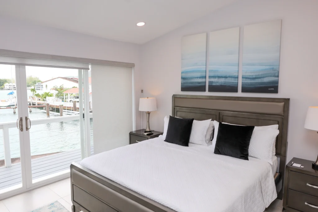 Two Bedroom Luxury villa main bedroom with a king bed and balcony doors to the marina