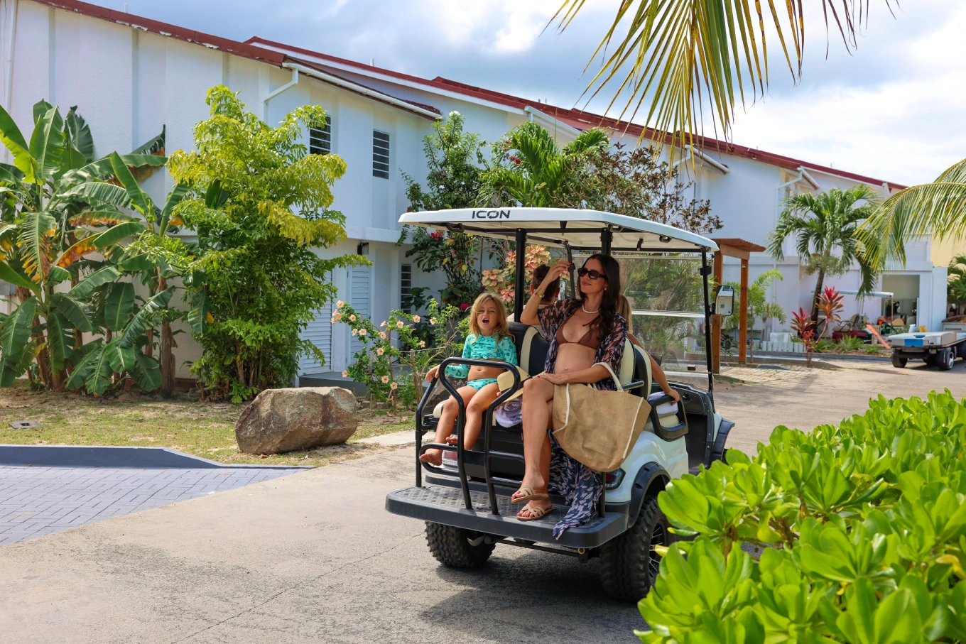 Mother and child riding a golf cart outside the villas in Jolly Harbour
